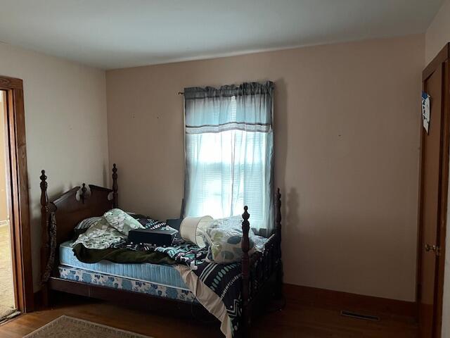 bedroom with dark hardwood / wood-style flooring