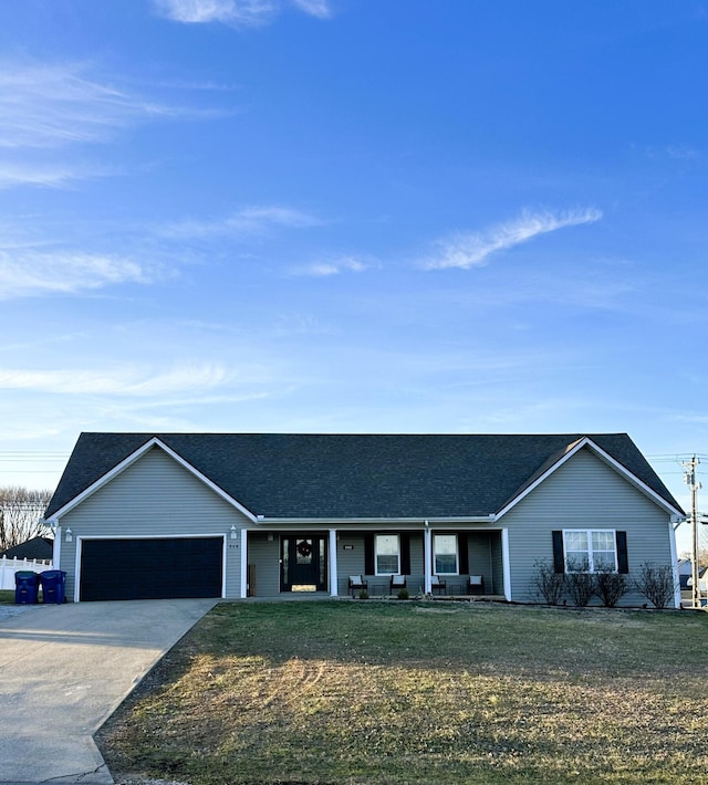 ranch-style home featuring a garage, covered porch, and a front yard