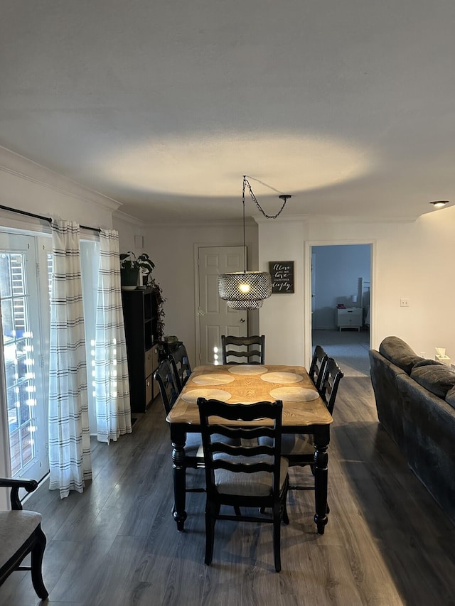 dining area featuring ornamental molding and dark hardwood / wood-style flooring