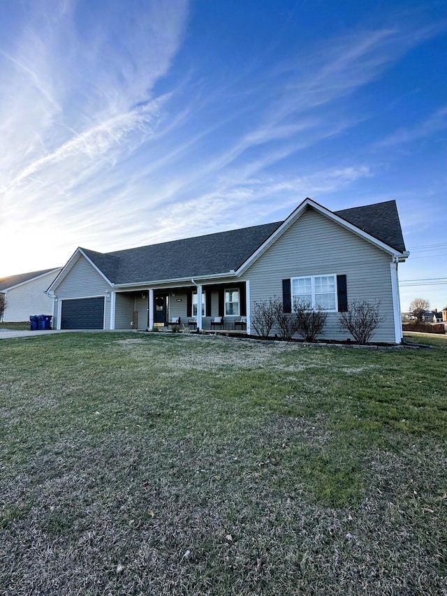 ranch-style home with a garage, a front yard, and covered porch