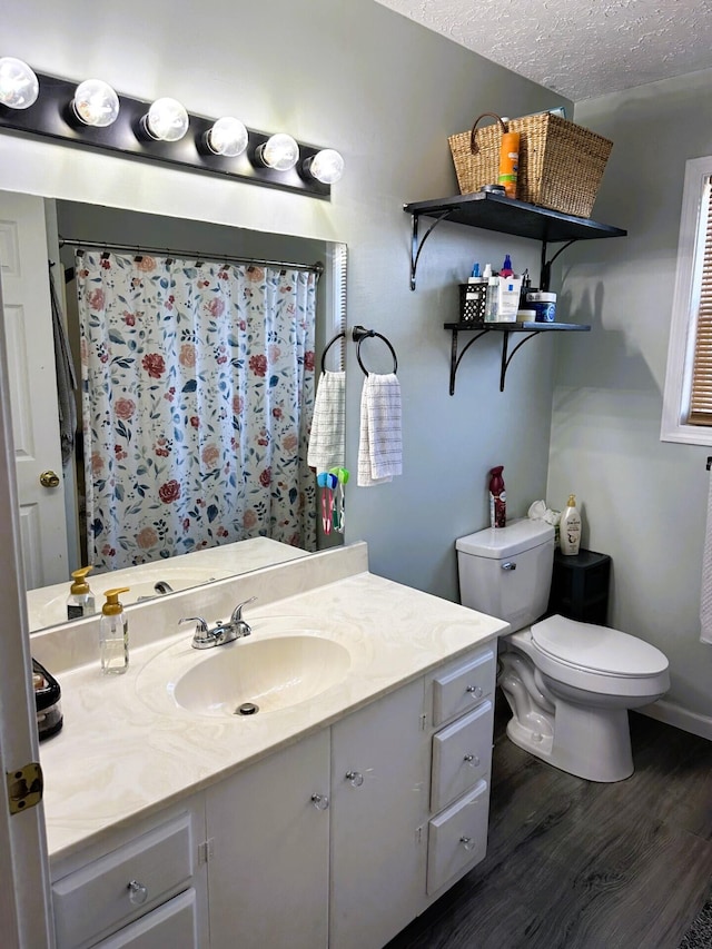 bathroom featuring vanity, hardwood / wood-style floors, toilet, and a textured ceiling