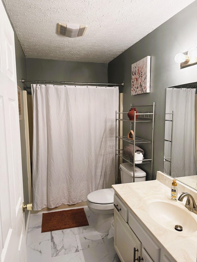 bathroom featuring vanity, toilet, a shower with shower curtain, and a textured ceiling