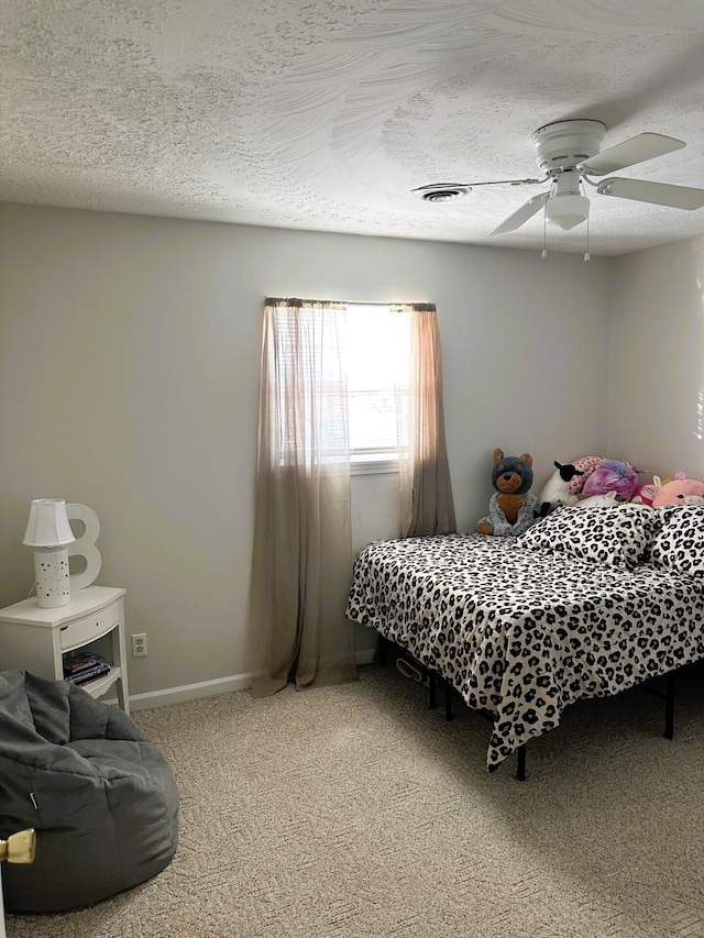 carpeted bedroom with ceiling fan and a textured ceiling