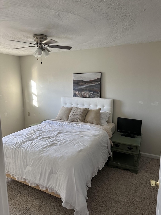 carpeted bedroom featuring ceiling fan and a textured ceiling