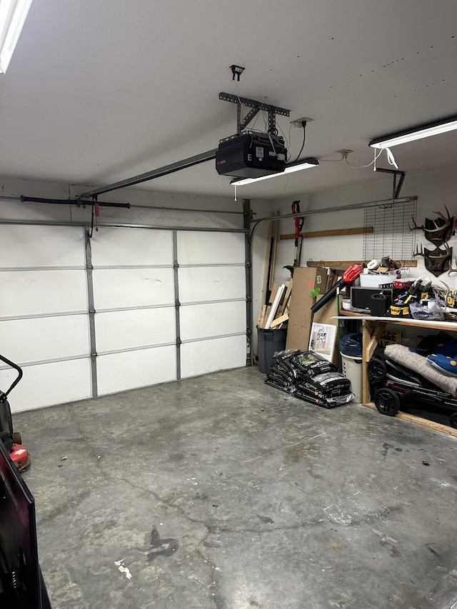 garage with a garage door opener and a workshop area