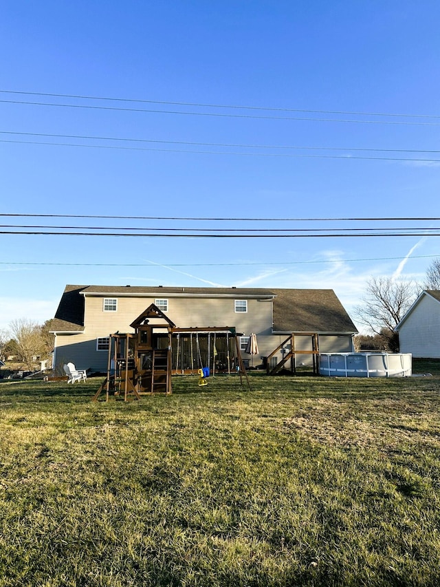 back of house with a yard and a playground