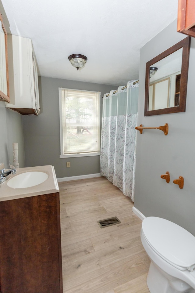 bathroom with vanity, hardwood / wood-style floors, toilet, and walk in shower