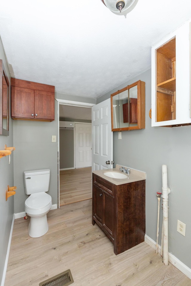 bathroom with vanity, hardwood / wood-style floors, and toilet