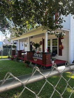 exterior space featuring covered porch and a lawn