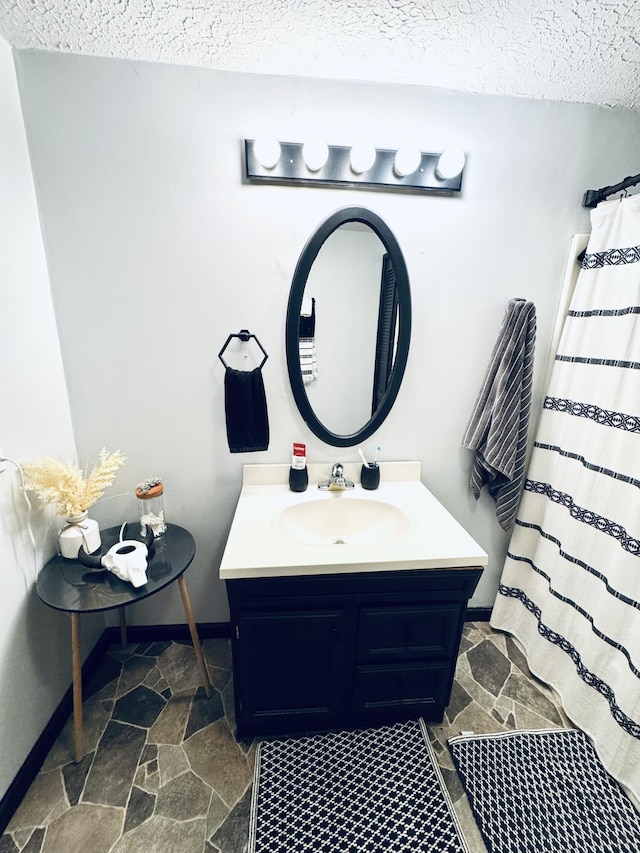 6002 Edmonton Rd, Columbia, KY 42728 - bathroom with a textured ceiling, vanity, baseboards, and stone finish floors