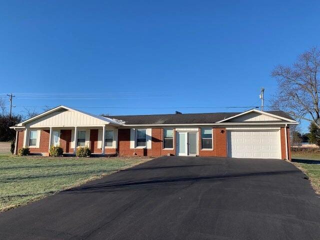 ranch-style house with a garage and a front lawn