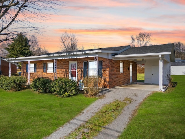 single story home featuring a carport and a lawn