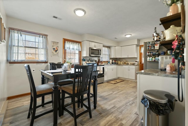 dining area featuring sink and light hardwood / wood-style flooring