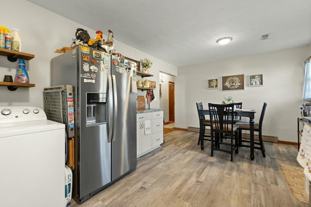 kitchen with stainless steel fridge, washer / clothes dryer, light wood-type flooring, and white cabinets