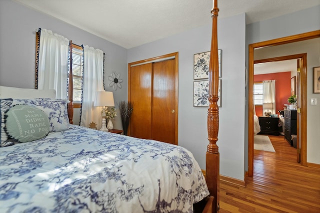 bedroom featuring a closet, hardwood / wood-style floors, and multiple windows