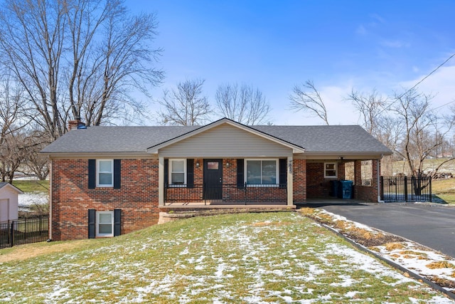 ranch-style house featuring brick siding, driveway, a chimney, and roof with shingles