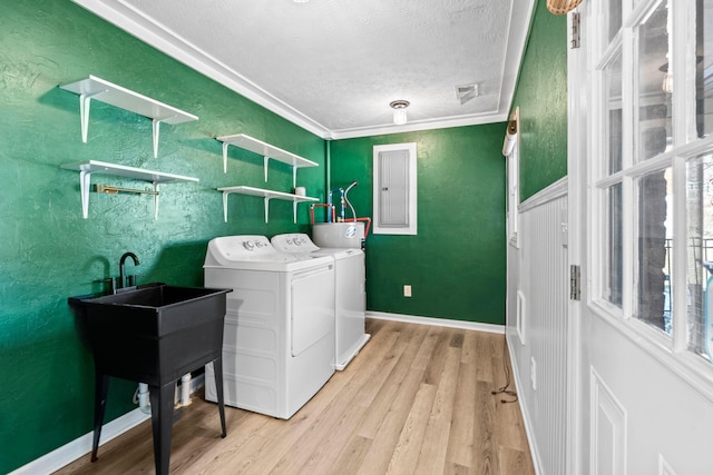 washroom featuring crown molding, washer and clothes dryer, a textured ceiling, light wood-type flooring, and laundry area