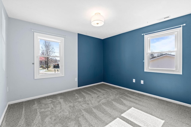 carpeted empty room with baseboards and visible vents