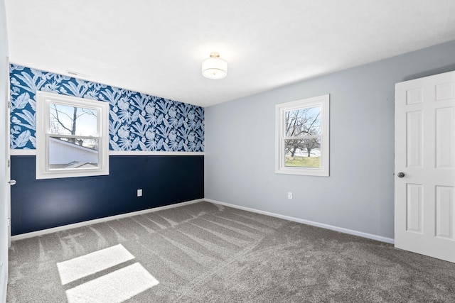 spare room featuring plenty of natural light, carpet flooring, and wallpapered walls