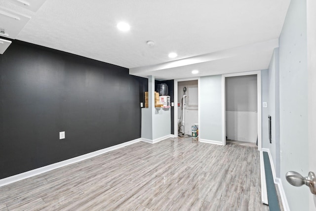 finished below grade area with recessed lighting, light wood-style flooring, and baseboards