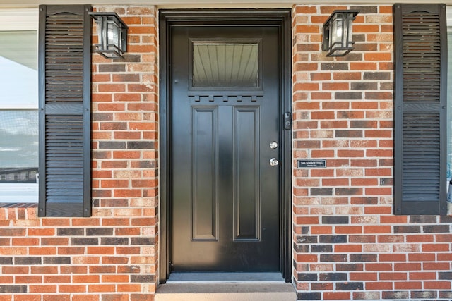 doorway to property with brick siding