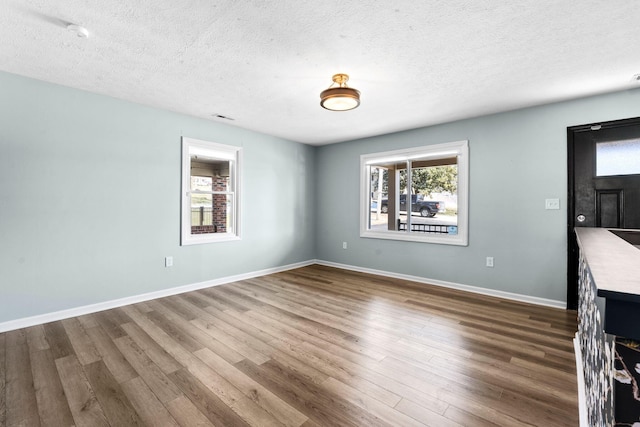 interior space with a textured ceiling, dark wood finished floors, and a wealth of natural light