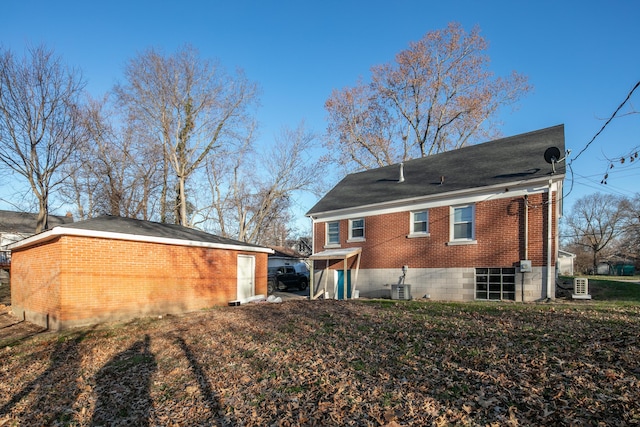 back of house featuring brick siding and cooling unit