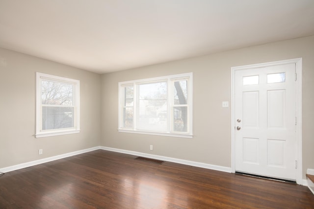 entryway with dark wood-style floors, visible vents, and baseboards