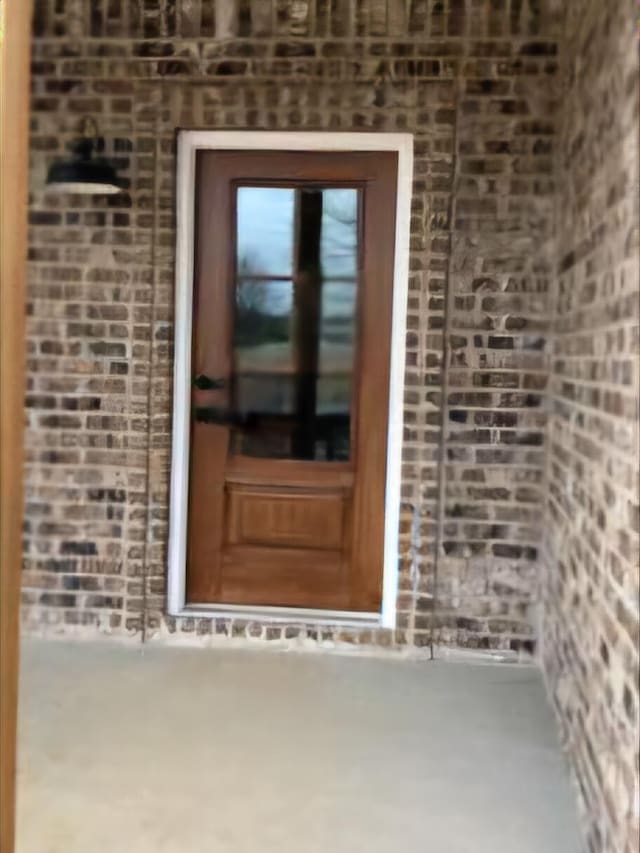 view of exterior entry with brick siding