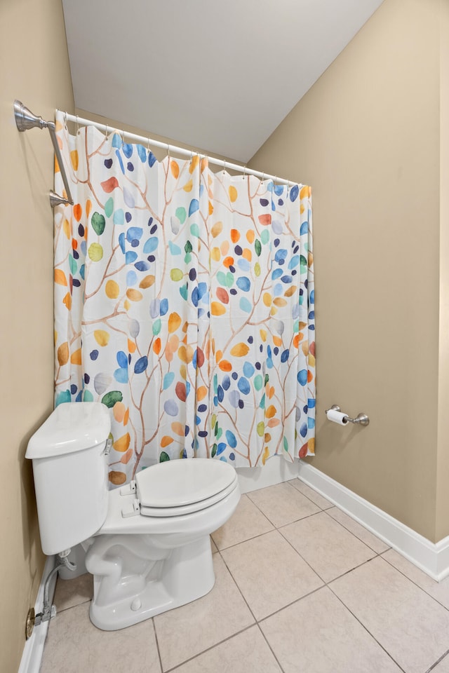 bathroom with tile patterned floors, curtained shower, baseboards, and toilet