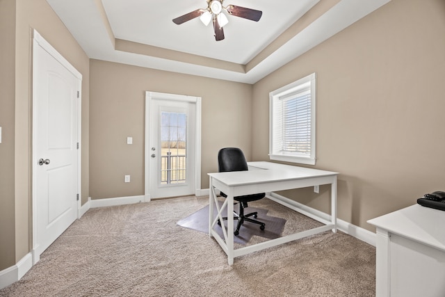 home office with baseboards, a raised ceiling, carpet, and a ceiling fan