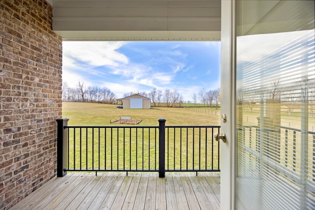 deck featuring an outbuilding, a yard, a rural view, and a shed