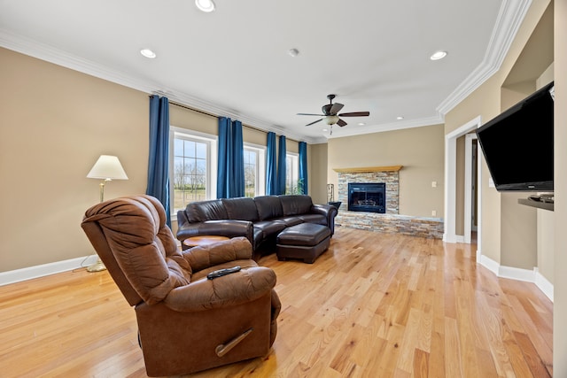 living room with a stone fireplace, baseboards, light wood-style floors, and ornamental molding