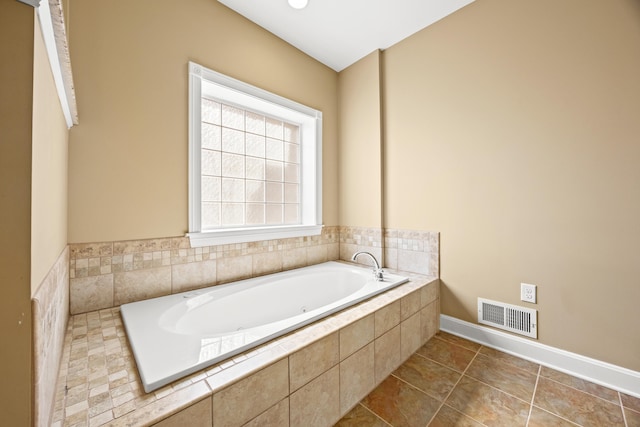 full bathroom featuring tile patterned flooring, visible vents, baseboards, and a garden tub