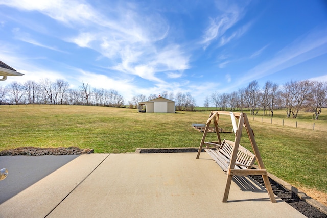 view of patio featuring a storage unit, an outbuilding, and a rural view