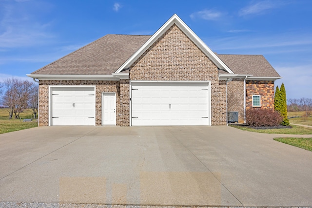 ranch-style home with a garage, brick siding, and a shingled roof