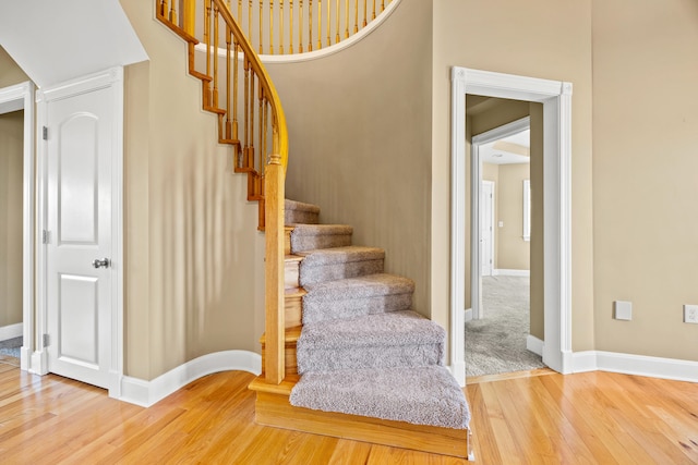 stairway with baseboards and wood finished floors