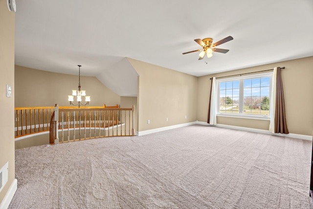 carpeted spare room with vaulted ceiling, ceiling fan with notable chandelier, and baseboards