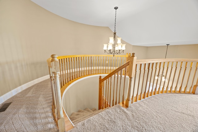 staircase featuring baseboards, visible vents, vaulted ceiling, carpet flooring, and a notable chandelier