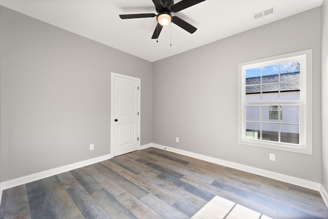 empty room with ceiling fan and dark hardwood / wood-style flooring