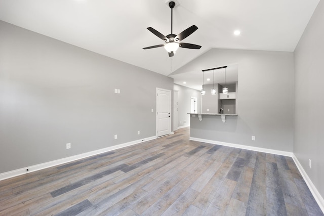 unfurnished living room with lofted ceiling, wood-type flooring, and ceiling fan