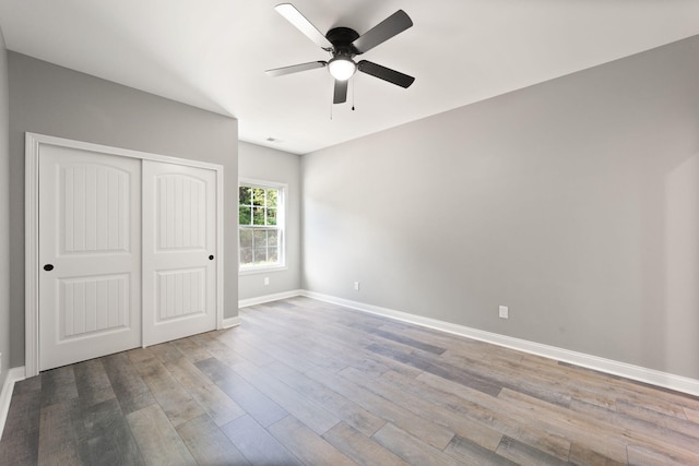 unfurnished bedroom featuring wood-type flooring, ceiling fan, and a closet