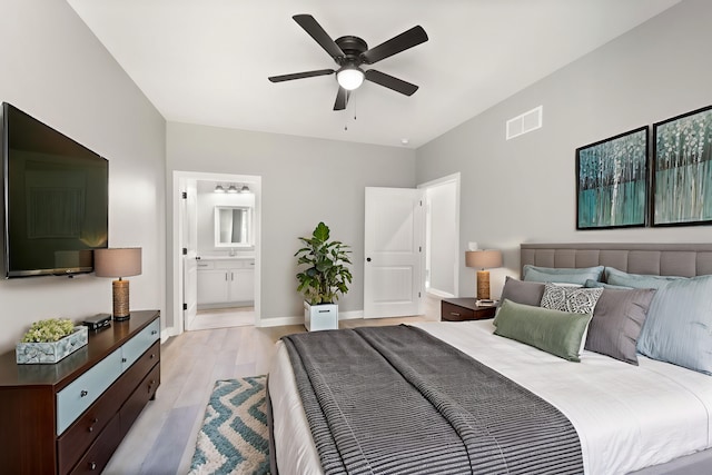 bedroom featuring sink, light hardwood / wood-style floors, ceiling fan, and ensuite bathroom