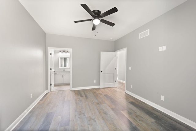 unfurnished bedroom featuring ensuite bathroom, sink, ceiling fan, and light hardwood / wood-style floors