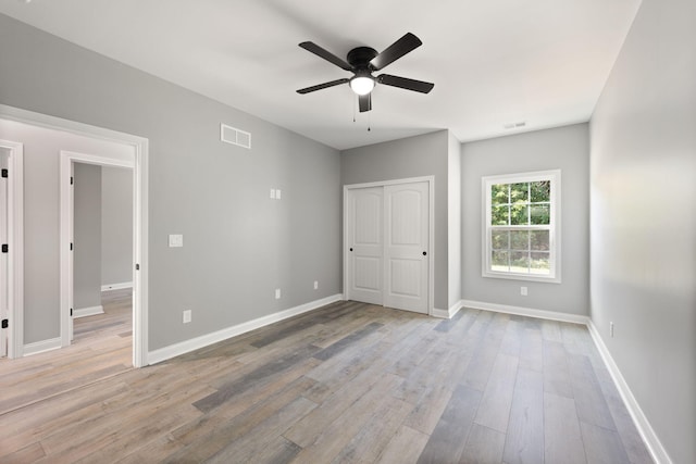 unfurnished bedroom with ceiling fan, light hardwood / wood-style floors, and a closet