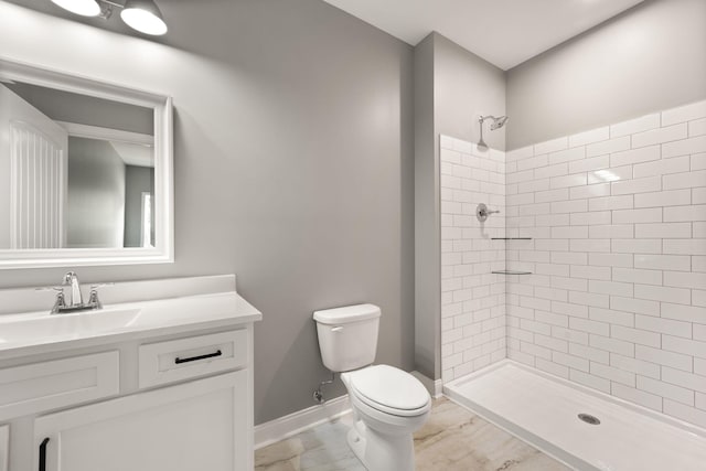 bathroom with vanity, toilet, and a tile shower