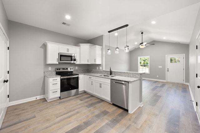 kitchen with white cabinetry, stainless steel appliances, kitchen peninsula, and sink