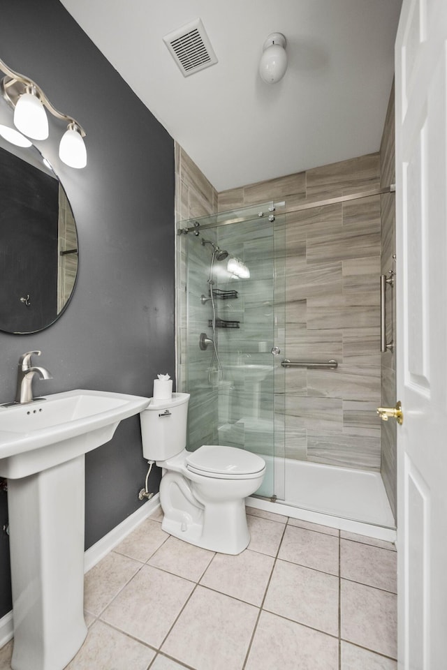 bathroom featuring toilet, tile patterned flooring, visible vents, and a shower stall