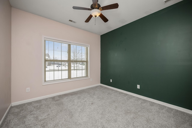 unfurnished room featuring a ceiling fan, carpet, visible vents, and baseboards