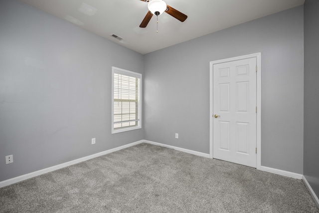 spare room featuring carpet, visible vents, and baseboards